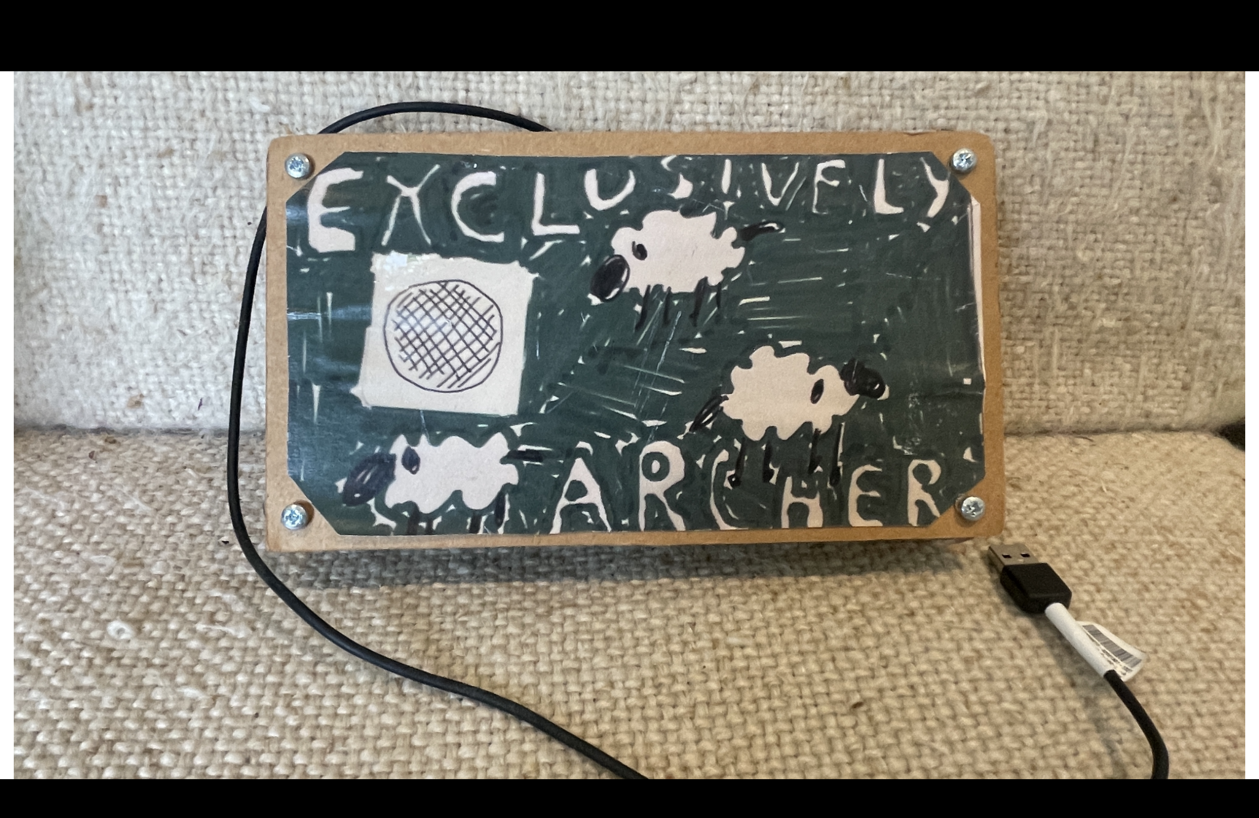 A cardboard box with a drawing of a sheep on it and the words 'exclusively archers'